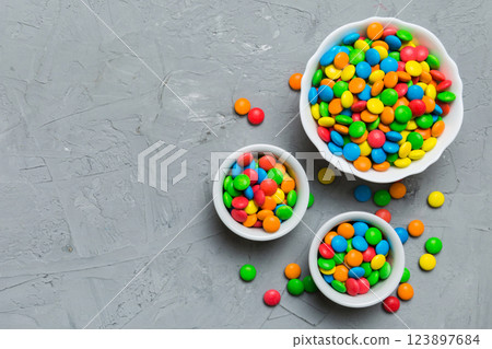 different colored round candy in bowl and jars. Top view of large variety sweets and candies with copy space 123897684