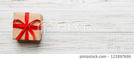 Valentine day composition: red gift box with bow and heart. Christmas present. View from above. Space for text. Holday greeting card Valentine day composition: red gift box with bow and heart. Christmas present. View from above. Space for text. Holday greeting card 123897686