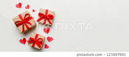 Valentine day composition: red gift box with bow and heart. Christmas present. View from above. Space for text. Holday greeting card Valentine day composition: red gift box with bow and heart. Christmas present. View from above. Space for text. Holday greeting card 123897691