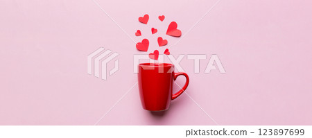 red cup on colored background, splashes of red little hearts, top view with copy space 123897699