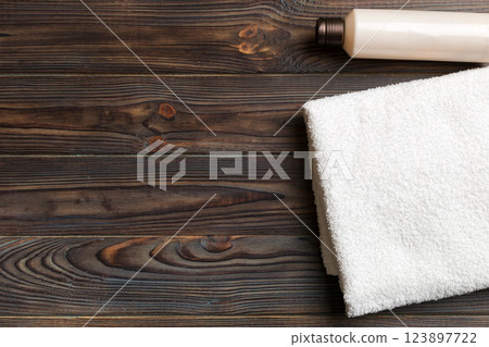 Cosmetic shampoo bottle mockup with towels on a colored table. Bathroom background, toilet accessories for hand and body care 123897722