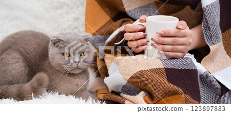 Female hands holding a white mug of coffee 123897883