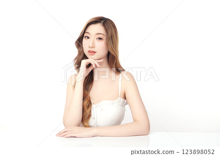 A beautiful young Asian woman with clean, fresh skin against a white background. She represents beauty, skincare, and spa treatments. 123898052