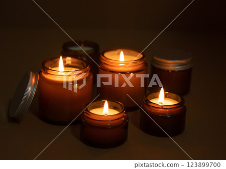 A set of different aroma candles in glass jars on a white background. Scented handmade candle. Soy candles are burning in a jar.Wax and paraffin in a jar A set of different aroma candles in glass jars on a white background. Scented handmade candle. Soy candles are burning in a jar.Wax and paraffin in a jar 123899700