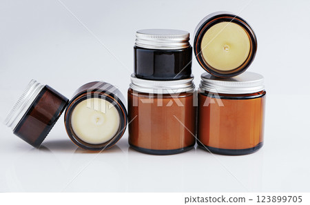 A set of different aroma candles in glass jars isolated on a white background. Scented handmade candle. Soy, wax and paraffin candles. A set of different aroma candles in glass jars isolated on a white background. Scented handmade candle. Soy, wax and paraffin candles. 123899705