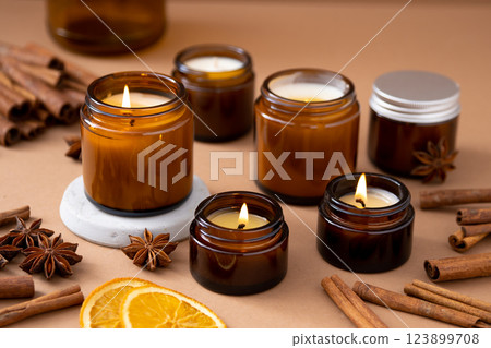 A set of different aroma candles in glass jars on a white background. Scented handmade candle. Soy candles are burning in a jar.Wax and paraffin in a jar A set of different aroma candles in glass jars on a white background. Scented handmade candle. Soy candles are burning in a jar.Wax and paraffin in a jar 123899708