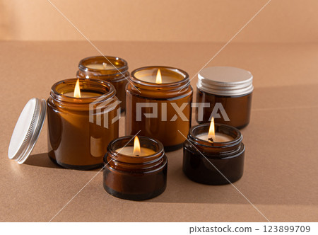 A set of different aroma candles in glass jars on a white background. Scented handmade candle. Soy candles are burning in a jar.Wax and paraffin in a jar A set of different aroma candles in glass jars on a white background. Scented handmade candle. Soy candles are burning in a jar.Wax and paraffin in a jar 123899709