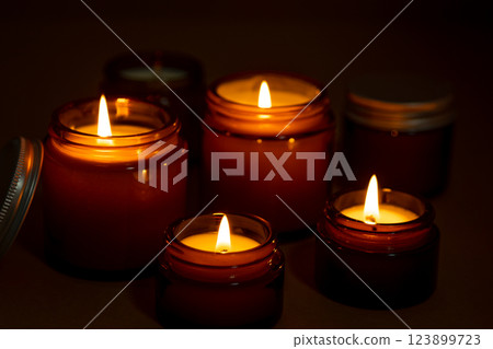 A set of different aroma candles in glass jars on a white background. Scented handmade candle. Soy candles are burning in a jar.Wax and paraffin in a jar A set of different aroma candles in glass jars on a white background. Scented handmade candle. Soy candles are burning in a jar.Wax and paraffin in a jar 123899723