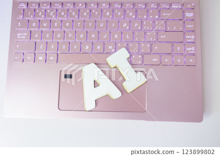 The word "AI" and a pink laptop The word "AI" and a pink laptop 123899802