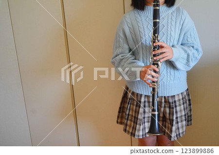 A fifth grade elementary school student who has been playing the clarinet for 1 year and 11 months practices the clarinet. A fifth grade elementary school student who has been playing the clarinet for 1 year and 11 months practices the clarinet. 123899886