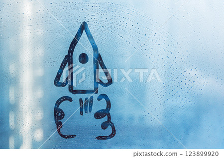 Doodle shape of rocket and its trail on foggy glass window on blue background Doodle shape of rocket and its trail on foggy glass window on blue background 123899920