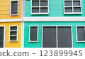 Colorful building facade with wooden panels and white window frames abstract 123899945