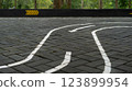Curved path on brick pavement with directional arrows for guidance 123899954