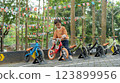 Young boy choosing balance bike in outdoor park setting for children 123899956