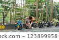 Young boy checking balance bike on outdoor course with flag decorations 123899958