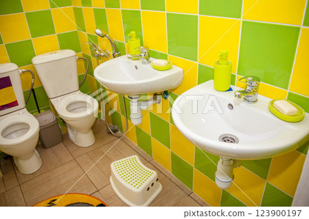 Toilet in kindergarten. White sinks and baby toilets. Hand wash stand, soap. Faucet in the bathroom. WC, 123900197