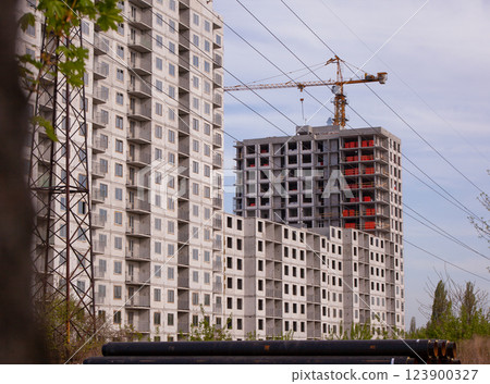 Construction of a new panel high-rise building. Modular house fast construction. Lifting crane. Multi-storey house. Construction site background 123900327