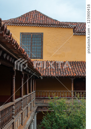 Traditional Spanish-style courtyard with wooden railings and terracotta roof tiles 123900416