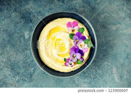 Elegant Hummus with Olive Oil and Edible Flowers in Dark Bowl Elegant Hummus with Olive Oil and Edible Flowers in Dark Bowl 123900697