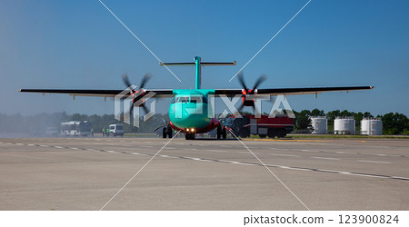 A plane with propellers takes off at the airport. Runway. Propeller 123900824