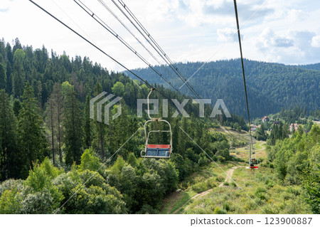 Ski lift in green forest. Cableway in Mountains. Summer nature. 123900887