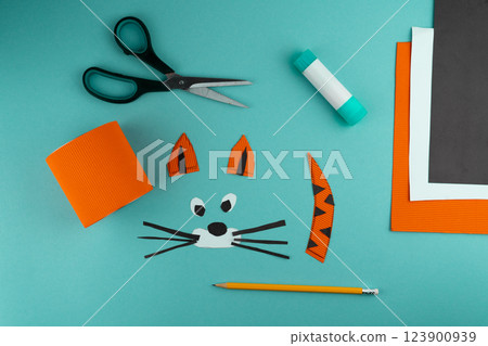 Step 5. Step-by-step instructions on how to make a stand for stationery from a tin can. Tiger made of paper and cardboard, scissors and glue. A fun DIY craft for children. Do it yourself paper tiger 123900939