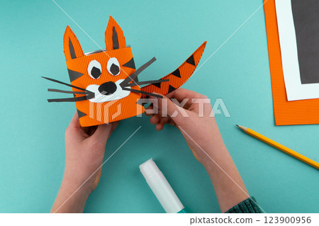 Step 7. Step-by-step instructions on how to make a stand for stationery from a tin can. Tiger made of paper and cardboard, scissors and glue. A fun DIY craft for children. Do it yourself paper tiger 123900956
