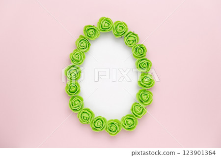 Pastel green rosebuds egg shape on pink background. Versatile Easter-themed composition perfect for backgrounds, greeting cards, social media, and seasonal marketing. 123901364