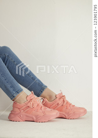 detail of sitting woman wearing pink trainers and jeans 123901795
