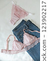 Woman's silk erotic lingerie on the white bed sheets. Valentine's day concept. Lace sexy female underwear. Beauty, fashion blogger concept. Female bra, panties, erotic clothes. Lingerie advertising 123902217