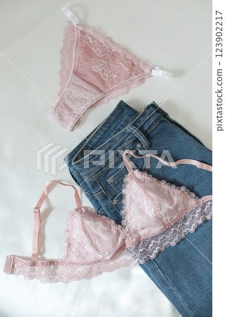 Woman's silk erotic lingerie on the white bed sheets. Valentine's day concept. Lace sexy female underwear. Beauty, fashion blogger concept. Female bra, panties, erotic clothes. Lingerie advertising 123902217