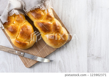 Traditional Easter braided bread. Tsoureki braid on white wooden table Traditional Easter braided bread. Tsoureki braid on white wooden table 123902371