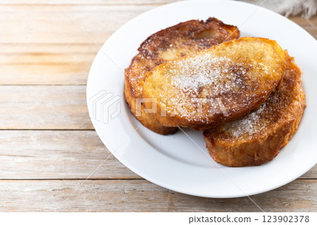 Traditional Spanish torrijas for Holy Week on wooden table. French Toast Traditional Spanish torrijas for Holy Week on wooden table. French Toast 123902378
