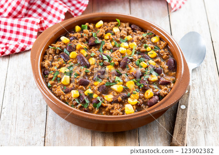 Traditional Mexican Chili con carne. Minced meat and vegetables stew in tomato sauce on wooden table 123902382