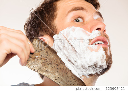 Scared man shaving having fun with machete. Scared man shaving having fun with machete. 123902421