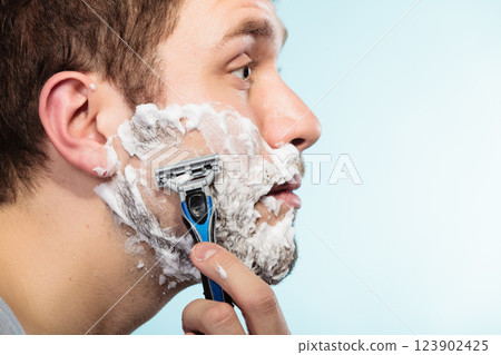 Man shaving with razor face profile Man shaving with razor face profile 123902425