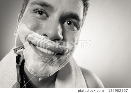 Happy man shaving using razor with cream foam. Happy man shaving using razor with cream foam. 123902567