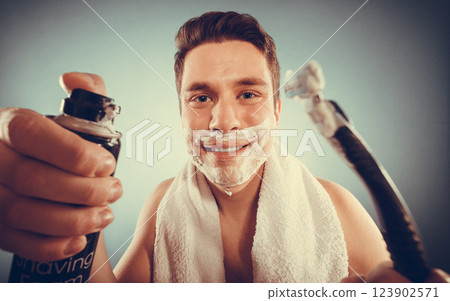 Handsome man with shaving cream foam can and razor 123902571