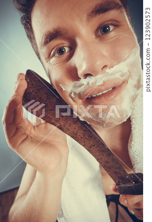 Young man shaving having fun with machete. 123902573