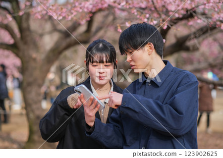 Young couple talking while looking at smartphone Young couple talking while looking at smartphone 123902625