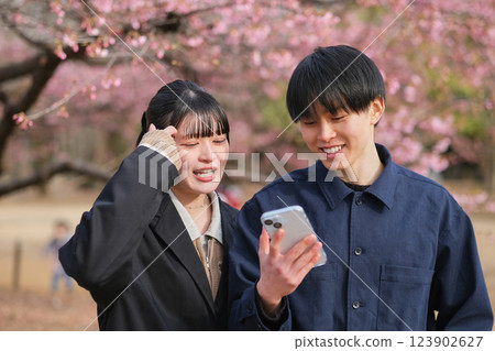 Young couple talking while looking at smartphone Young couple talking while looking at smartphone 123902627