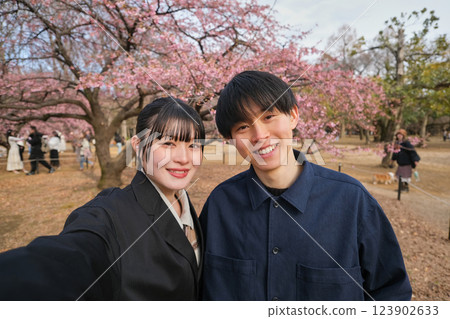 A couple taking a selfie with plum blossoms in the background 123902633