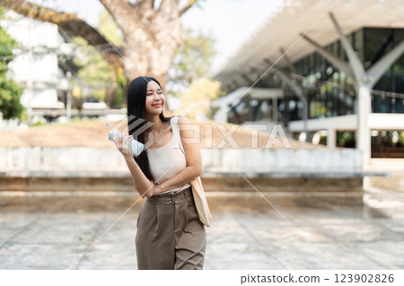 Sustainable lifestyle. Woman posing with a reusable water bottle outdoors. 123902826