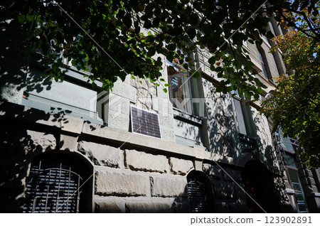 Photovoltaic solar panel in front of historical building. Concept of integration of sustainable renewable energy sources into old architecture. 123902891