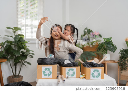 Recycling Education and Bonding Moments. A mother and daughter sharing a learning experience about recycling techniques. 123902916