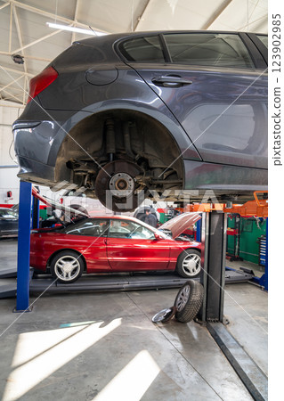 Car service workshop with cars on a column lifts Car service workshop with cars on a column lifts 123902985