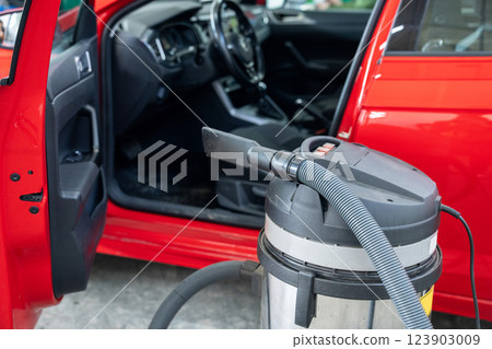 Vacuum cleaner next to the car. Interior dry cleaning 123903009