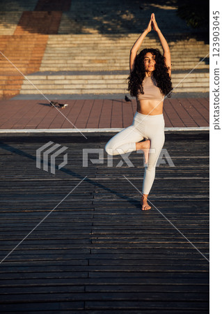 woman doing gymnastics yoga asana outdoors 123903045