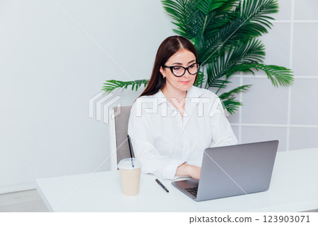 woman working at desk with laptop in online office training woman working at desk with laptop in online office training 123903071