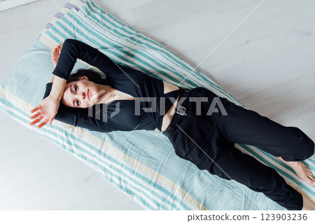 Beautiful fashionable brunette woman lying on sleeping mattress Beautiful fashionable brunette woman lying on sleeping mattress 123903236